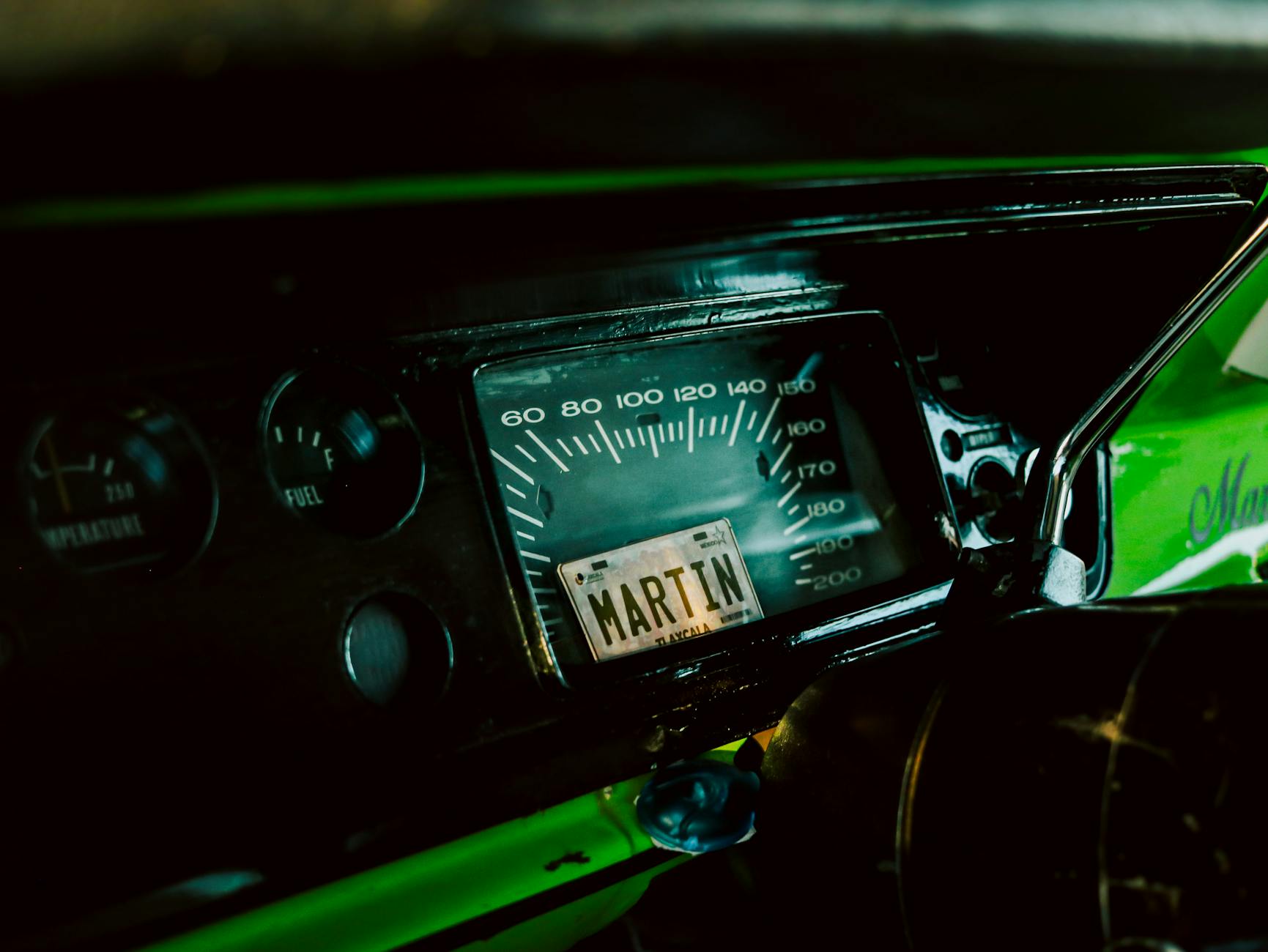 Close-up of a vintage car dashboard featuring a speedometer and unique details.