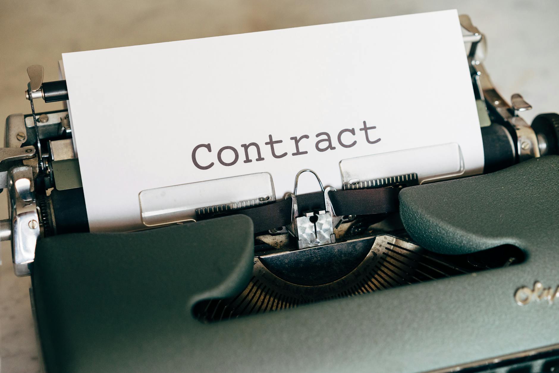 A close-up of a vintage typewriter with a typed contract page.
