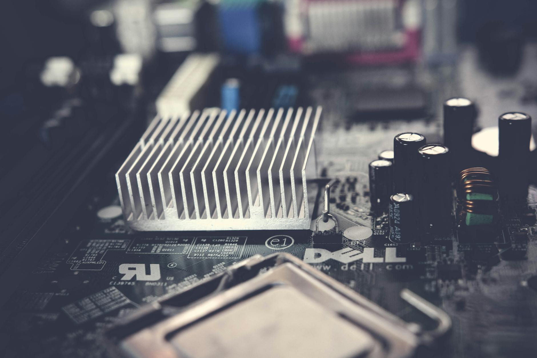 Detailed view of a computer motherboard featuring a heatsink and electronic components, showcasing modern technology.
