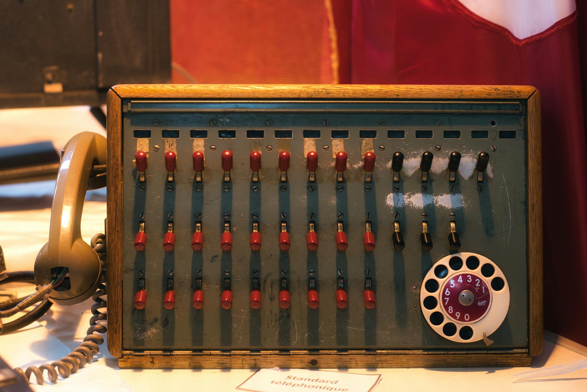 Classic telephone switchboard featuring rotary dial and toggle switches in a vintage setting.