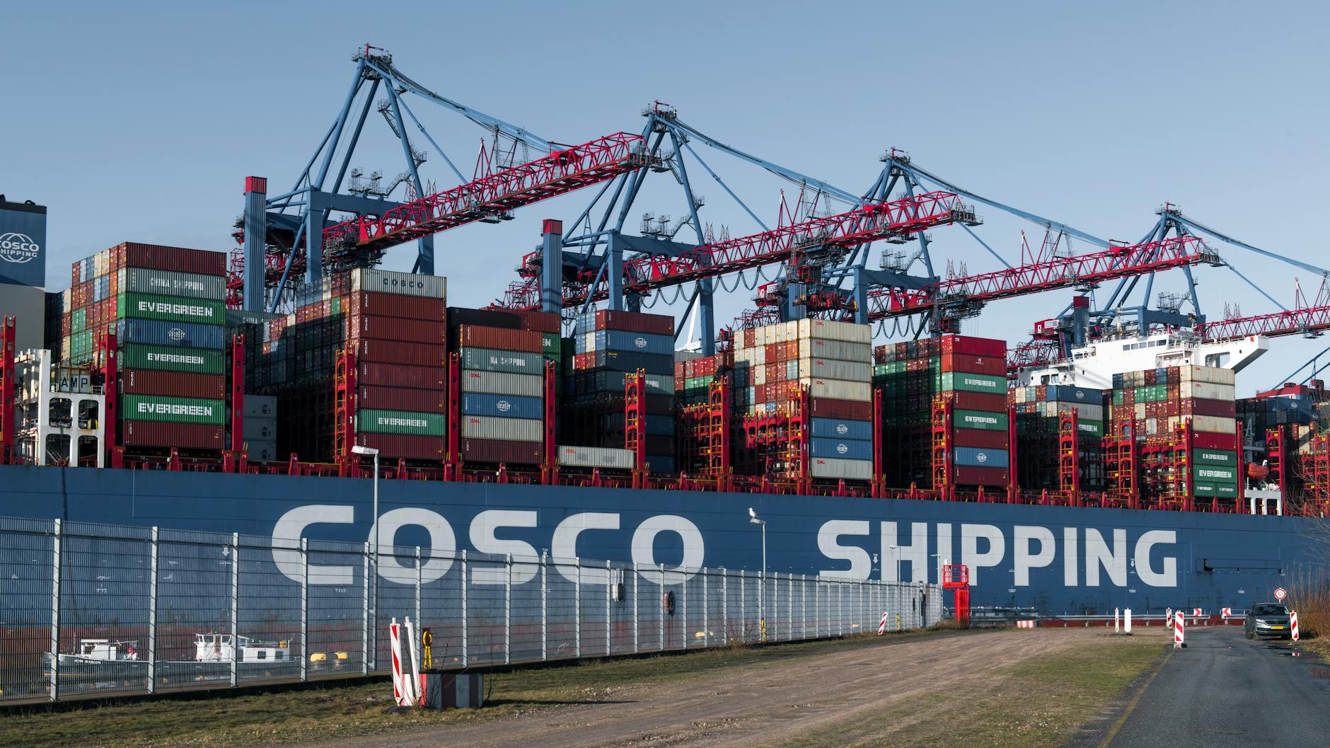 Large container ship and cranes at Hamburg port showcasing global trade and logistics operations.