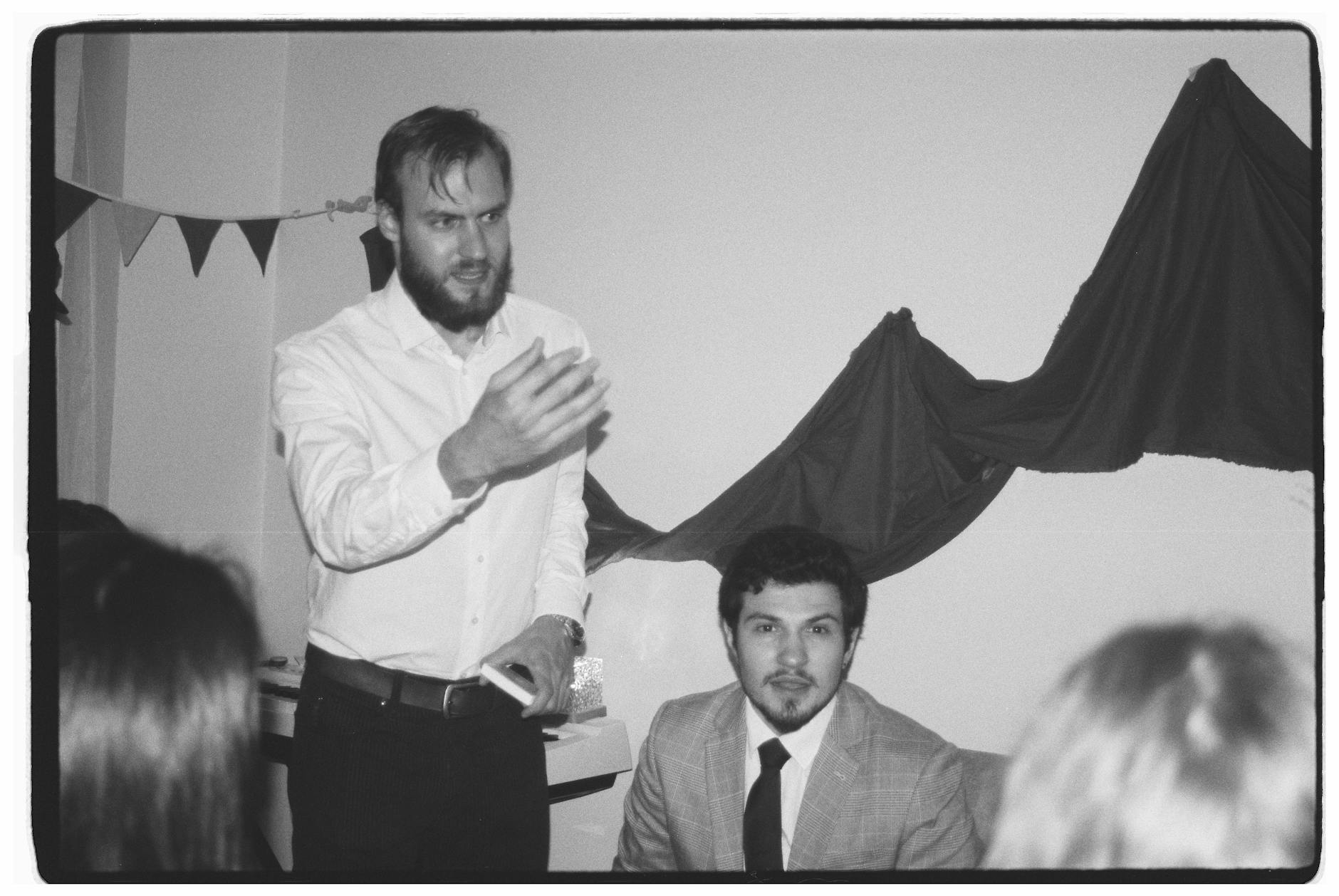 A dynamic black and white photo of a team meeting with engaged participants.