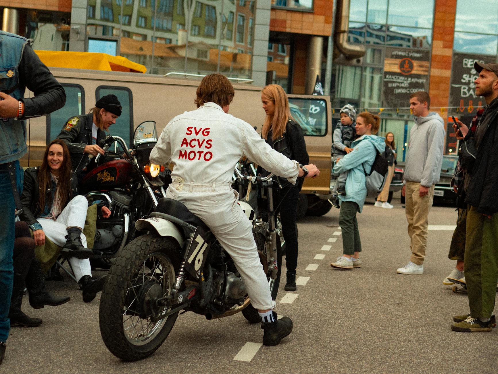 Motorcycle enthusiasts gather at an urban street event, showcasing bikes and culture.