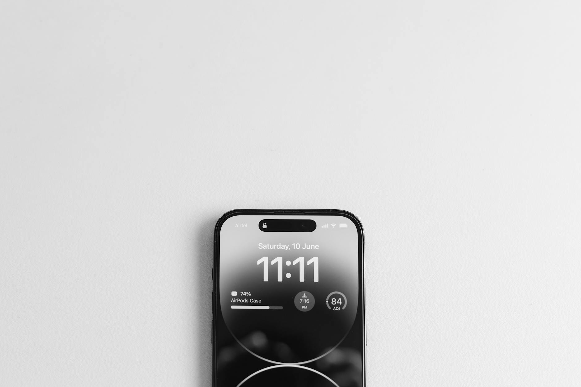 Top view of a smartphone displaying the time 11:11, on a minimalist white background.