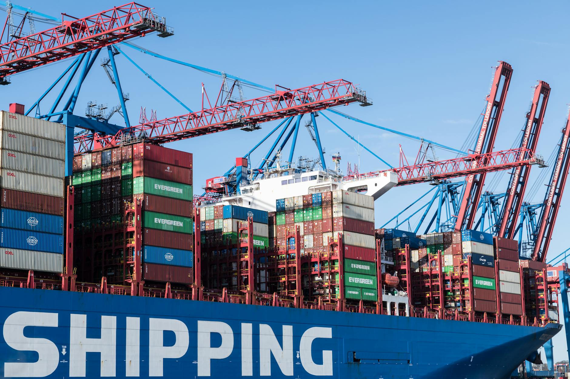 Shipping containers and cranes at Hamburg port showcasing global trade.